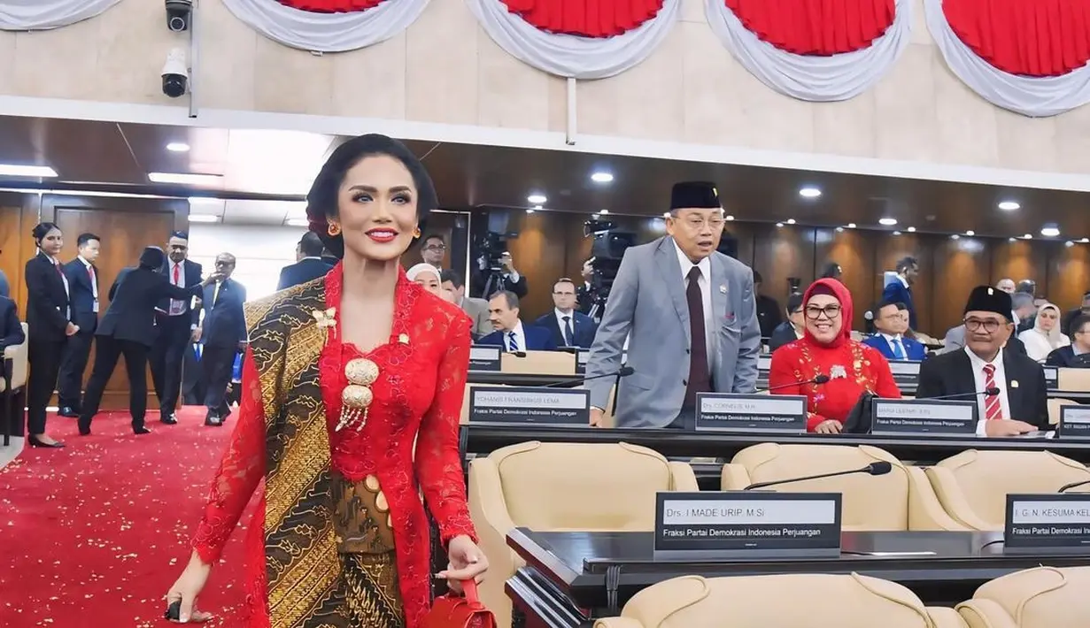 Saat sidang DPR jelang HUT ke-79 RI, Krisdayanti tampil ayu dengan kebaya merah. Ia padukan kebaya kutubaru brukat dengan kain batik sebagai angkin, selendang dan bawahan. [@krisdayantilemos]