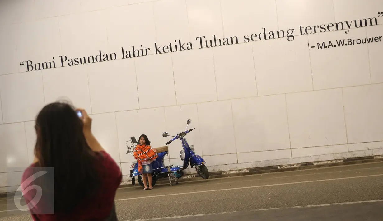 Seorang anak kecil berpose di depan mural bertema Kota Bandung di Jalan Asia Afrika, Bandung, Jawa Barat, Selasa (5/7). Dua buah mural tersebut menjadi lokasi favorit bagi warga dan wisatawan di Bandung untuk berfoto. (Liputan6.com/Immanuel Antonius)