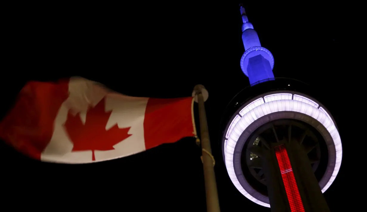 The landmark CN Tower menyala dengan warna bendera Prancis yaitu warna biru, putih dan merah di Toronto (13/11). Aksi ini sebagai ungkapan belasungkawa menyusul serangan teror di Perancis. (REUTERS/Chris Helgren)