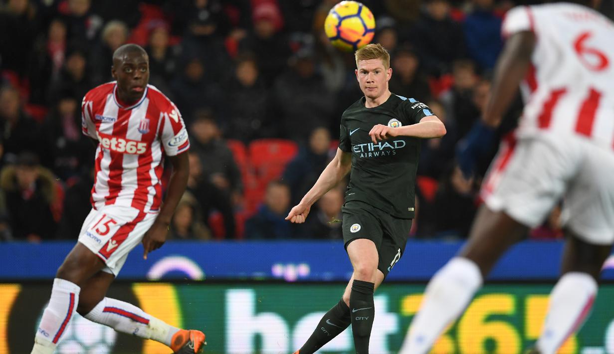 Pemain Manchester City, Kevin De Bruyne (tengah) melepaskan umpan melewati adangan para pemain Stoke City pada lanjutan Premier League di Bet 365 Stadium, Stoke, (13/3/2018). Manchester City menang 2-0. (AFP/Paul Ellis)