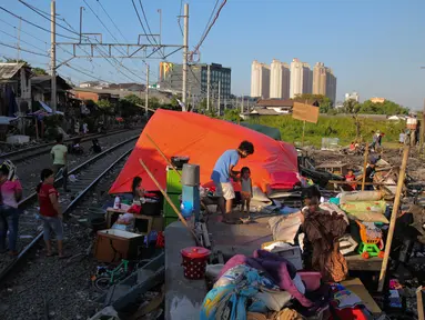 Aktivitas warga korban kebakaran Kampung Bandan, Jakarta, Senin (18/9). Hari kedua pasca kebakaran warga masih bertahan di lokasi bekas kebakaran dengan membangun tenda seadanya. (Liputan6.com/Faizal Fanani)