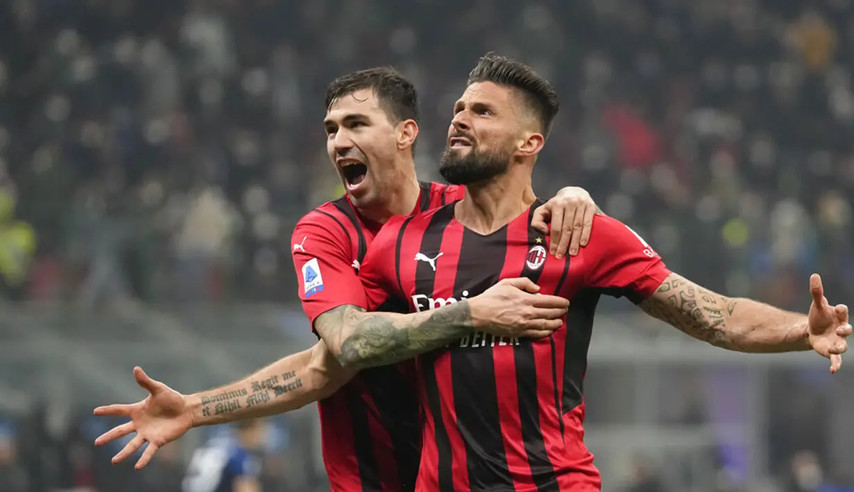 Pemain AC Milan Olivier Giroud (kanan) merayakan dengan Alessio Romagnoli usai mencetak gol ke gawang Inter Milan pada pertandingan sepak bola Liga Italia di Stadion San Siro, Milan, Italia, 5 Februari 2022. AC Milan menang 2-1. (AP Photo/Antonio Calanni)