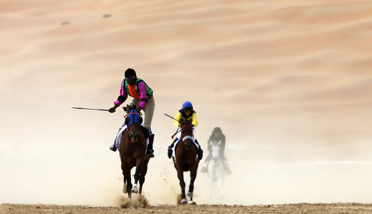 Para joki beraksi dalam lomba balap kuda Festival Moreeb Dune 2016 di gurun Liwa, 250 km barat Abu Dhabi. (AFP/Karim Sahib)