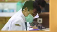 Siswa di Kota Malang, Jawa Timur, mengenakan masker untuk mencegah penularan difteri yang telah menyerang sejumlah guru dan murid, Senin, 16 Oktober 2017. (Zainul Arifin/Liputan6.com)