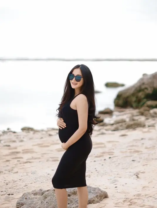 Pertama dalam konsep kasual di pantai, Bella tampil menawan dengan bodycon dress hitamnya. [@bellabonita_r.a]