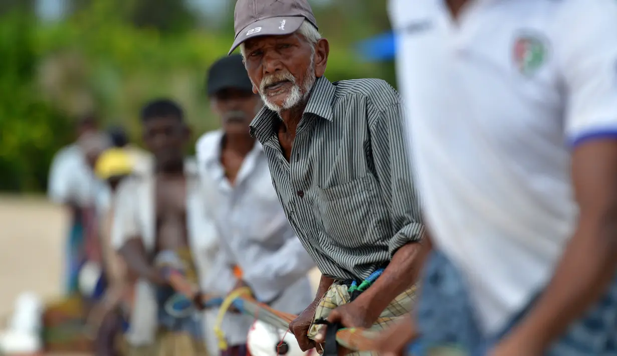 Para nelayan Sri Lanka menarik jaring ikan di pantai di Trincomalee (5/5). Trincomalee adalah kota pelabuhan di bagian timur Sri Lanka. (AFP Photo/Ishara S Kodikara)