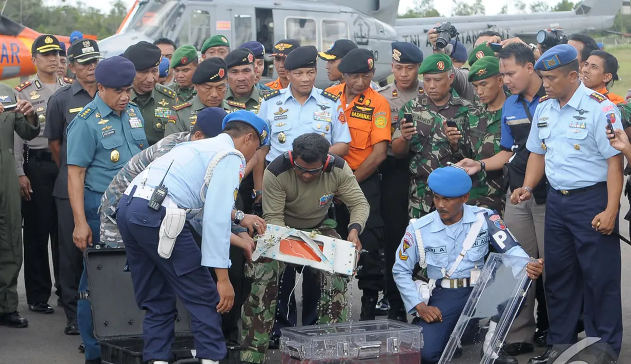 Tim SAR Gabungan memindahkan FDR (Flight Data Recorder) dari koper penyimpanan ke kotak khusus milik KNKT (Komite Nasional Keselamatan Transportasi) di Lanud Iskandar, Pangkalan Bun, Kalteng, Senin (12/01/2015). (Liputan6.com/Andrian M Tunay)
