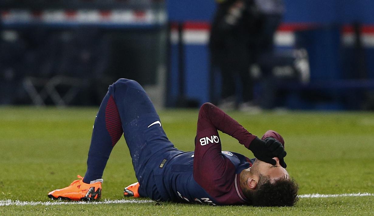 Neymar terbaring kesakitan usai berebut bola dengan pemain Marseille pada lanjutan Ligue 1 Prancis di Parc des Princes Stadium, Paris, (25/2/2018). PSG menang 3-0. (AP/Thibault Camus)