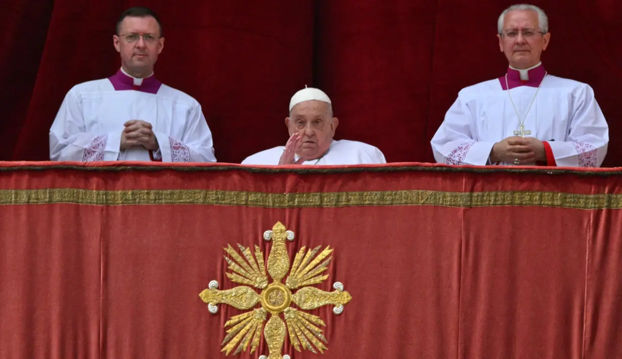Paus Fransiskus (tengah) saat berada di balkon utama Basilika Santo Petrus sebelum menyampaikan pesan Urbi et Orbi atau kepada kota (Roma) dan dunia sebagai bagian dari perayaan Paskah, di alun-alun Santo Petrus di Vatikan pada tanggal 20 April 2025. (Andreas SOLARO/AFP)