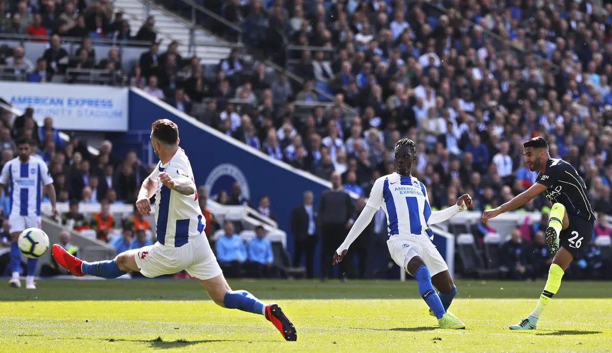 Gelandang Manchester City, Riyad Mahrez, mencetak gol ke gawang Brighton and Hove Albion pada laga Premier League di Stadion AMEX, Minggu (12/5). Manchester City menang 4-1 atas Brighton and Hove Albion. (AP/Frank Augstein)