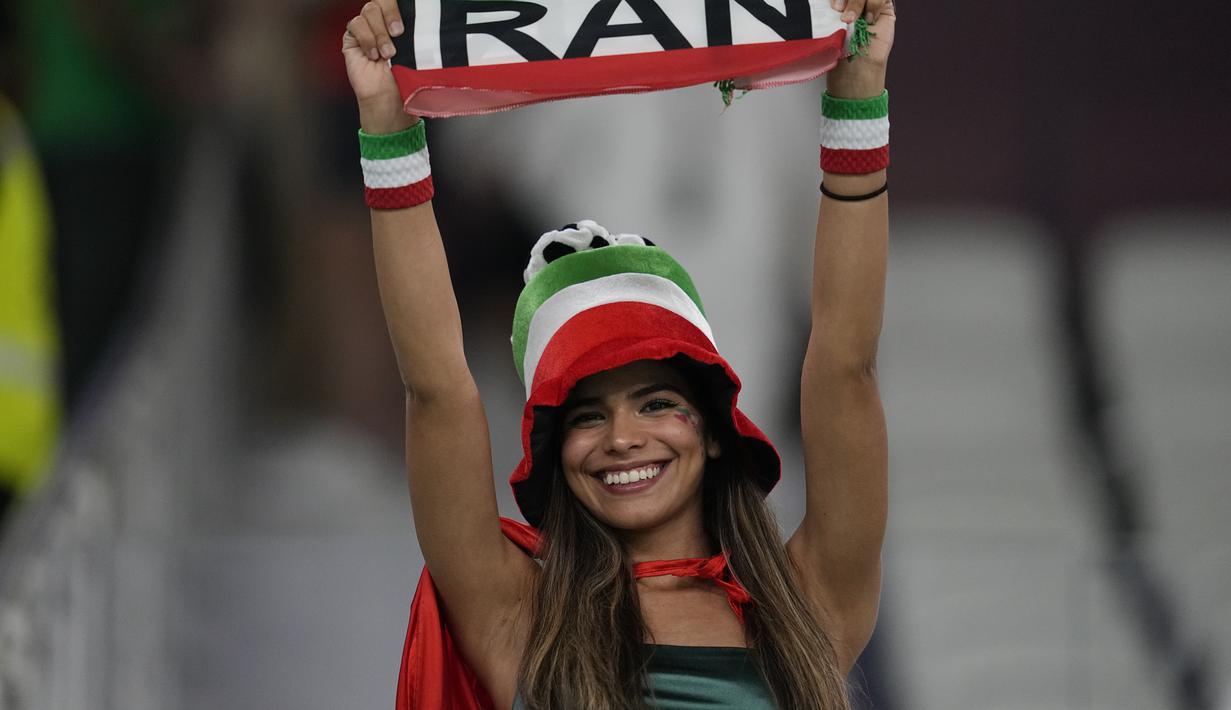 Seorang fans wanita Iran tersenyum menjelang pertandingan  grup B Piala Dunia antara Iran melawan Amerika Serikat di Stadion Al Thumama di Doha, Qatar, Selasa, 29 November 2022. (AP Photo/Ebrahim Noroozi)