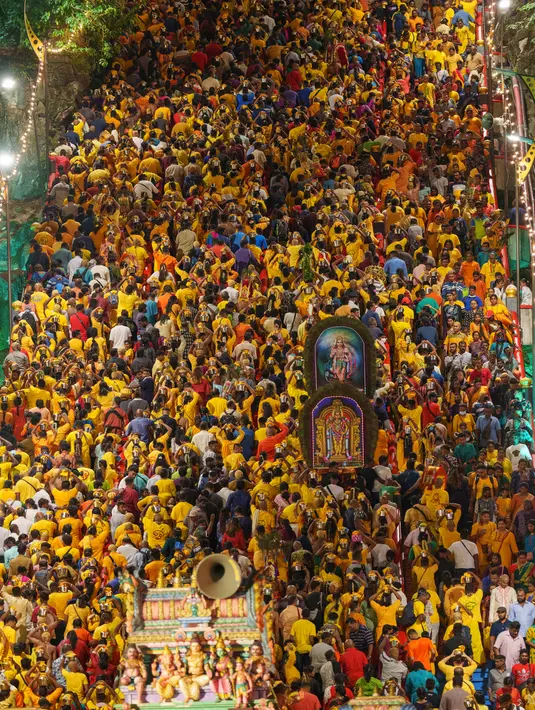 Umat Hindu membawa kanopi berhias yang disebut “kavadi” saat menaiki 272 anak tangga menuju Kuil Sri Subramaniar Swamy pada perayaan Thaipusam di Batu Caves, Kuala Lumpur, Malaysia, Minggu (5/2/2023). Thaipusam, yang dirayakan untuk menghormati Dewa Murugan, adalah acara tahunan umat Hindu untuk mencari berkah, memenuhi sumpah, dan mengucapkan terima kasih. (AP Photo/Vincent Thian)