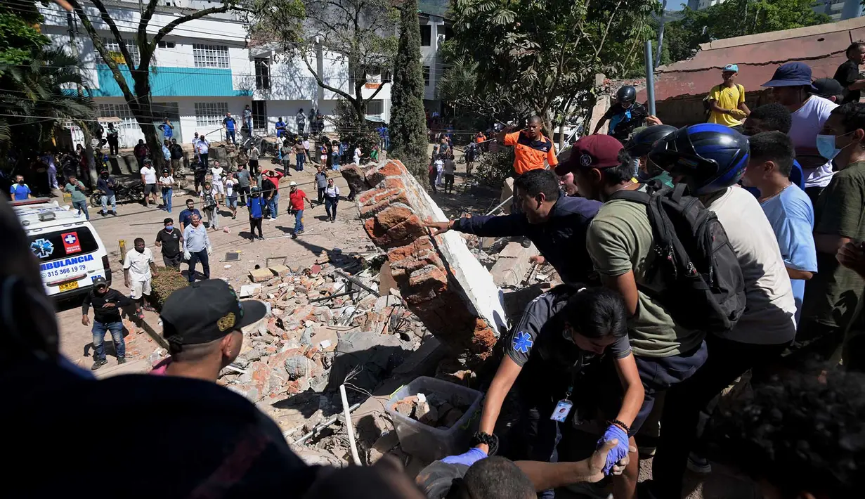 Sejumlah orang mencari korban yang tertimbun  bangunan yang runtuh akibat gempa bumi di Cali, Kolombia, Senin, 10 Agustus 2026 (AFP/ Joaquin Sarmiento)