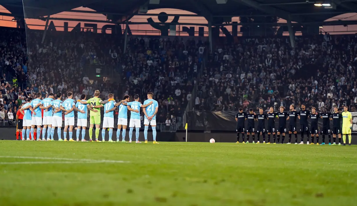 Pemain Sturm Graz dan Lazio mengheningkan cipta selama satu menit untuk mengenang para korban tewas dalam tragedi Kanjuruhan sebelum pertandingan sepak bola Grup F Liga Europa di Merkur Arena, Graz, Austria, 6 Oktober , 2022. (AP Photo/Florian Schroetter)