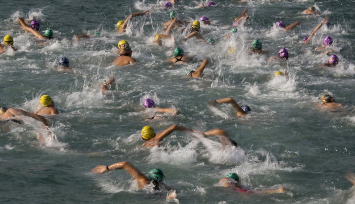 Perenang berkompetisi dalam lomba renang lintas pelabuhan di Hong Kong, Minggu (18/10). 2.500 orang ambil bagian dalam menembus jarak lintasan laut sejauh 1,5 km dari Sam Ka Tsuen Public Pier ke Quarry Bay Park Public Pier. (REUTERS/Tyrone Siu)