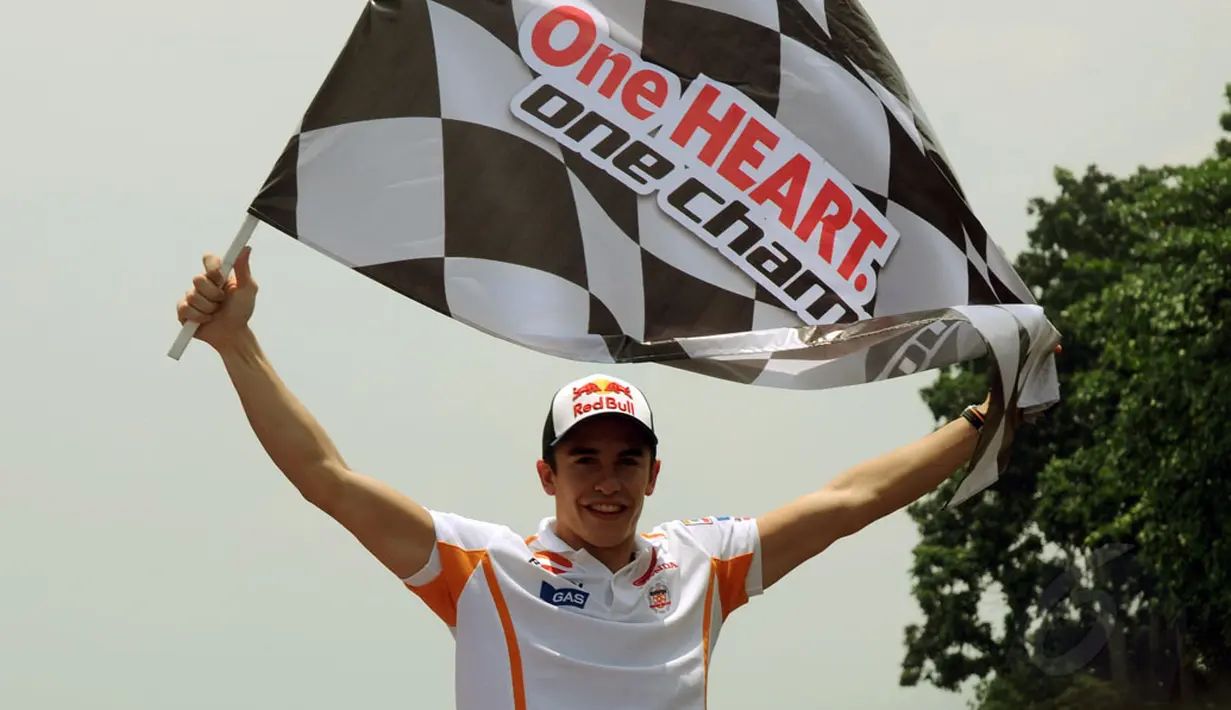 Juara Dunia MotoGP 2013 dan 2014, Marc Marquez membentangkan bendera start di Sirkuit Sentul, Bogor, (21/10/2014). (Liputan6.com/Helmi Fithriansyah)