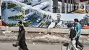 Pejalan kaki melintas di dekat poster desain proyek pembangunan Pasar Senen Blok I dan II, Jakarta, Minggu (15/11/2020). Rencananya, proyek senilai Rp 900 miliar tersebut akan dibangun menjadi kawasan berorientasi transit (TOD) dan ditargetkan rampung pada 2022. (merdeka.com/Iqbal S Nugroho)