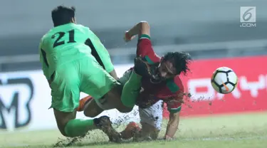 Bek Indonesia U-23, Gavin Kwan Adsit (kanan) berjibaku dengan penjaga gawang Uzbekistan, Ergashev Umidion pada laga PSSI Anniversary 2018 di Stadion Pakansari, Kab Bogor, Kamis (3/5). Laga berakhir imbang 0-0. (Liputan6.com/Helmi Fithriansyah)