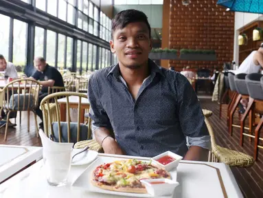 Pemain Sriwijaya FC, Ferdinand Sinaga menikmati Piza usai menjalani sidang Komisi Disiplin di Hotel Century, Senayan. Jakarta, Jumat (4/12/2015). (Bola.com/Nicklas Hanoatubun)