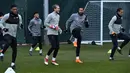 Kiper Liverpool, Loris Karius (kedua kiri) berbincang dengan Emre Can saat melakukan pemanasan saat latihan di Melwood Training Ground, Liverpool, (5/3). Liverpool akan melawan Porto pada leg kedua babak 16 besar Liga Champions. (AFP Photo/Anthony Devlin)