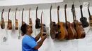 Pekerja tengah merapikan gitar di workshop I Wayan Tuges gitar berlabel Blueberry di Jalan Baruna No. 5 Guwang, Sukowati, Bali, Senin (15/10). Gitar tersebut banyak dipesan oleh musisi lokal hingga mancanegara. (Liputan6.com/Angga Yuniar)