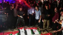 Warga Palestina berkumpul mengelilingi jenazah warga Palestina yang tewas dalam serangan Israel selama perang dengan Hamas setelah ditemukan dari bawah reruntuhan bangunan. Jenazah yang dibungkus bendera Palestina tersebut diiringi warga dalam prosesi pemakaman di Kota Gaza, Rabu (30/9/2026). Prosesi berlangsung dalam suasana duka, dengan keluarga dan warga setempat berkumpul untuk memberikan penghormatan terakhir kepada para korban. (AP Photo/Jehad Alshrafi)