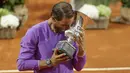 Petenis Spanyol, Rafael Nadal mencium trofi juara turnamen tenis Italia Terbuka 2021 setelah mengalahkan petenis Serbia, Novak Djokovic di Foro Italico, Roma, Minggu (16/5/2021). Rafael Nadal menang dalam pertarungan tiga set 7-5, 1-6, dan 6-3 selama dua jam 49 menit. (AP Photo/Gregorio Borgia)