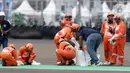 Marshal membersihkan lintasan jelang kualifikasi MotoGP di Pertamina Mandalika International Street Sirkuit, Lombok, Sabtu (19/3/2022). Pit Marshals bertugas dan berbasis di area pitlane dan mereka akan membantu ketika ada insiden di pit. (Liputan6.com/Helmi Fithriansyah)