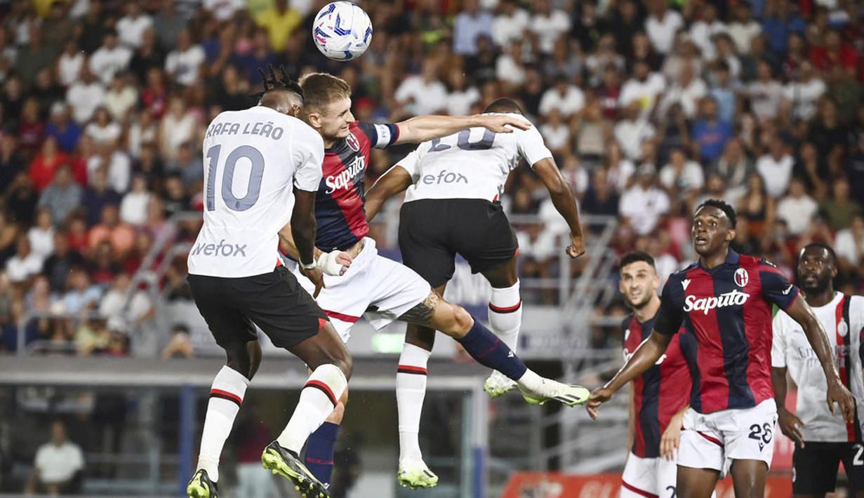 Pemain AC Milan, Rafael Leao, duel udara dengan pemain Bologna, Stefan Posch, pada pekan pertama Serie A di Stadion Renato Dall'Ara, Selasa (22/8/2023). AC Milan menang dua gol tanpa balas. (Massimo Paolone/LaPresse via AP)