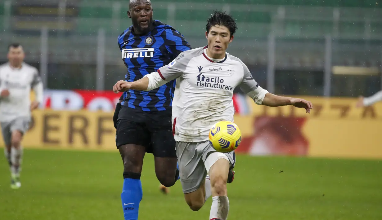 Bek Bologna, Takehiro Tomiyasu membawa bola dari kejaran penyerang Inter Milan, Romelu Lukaku pada pertandingan lanjutan Liga Serie A Italia di Stadion San Siro Milan, Minggu (6/12/2020). Inter menang 3-1 atas Bologna. (AP Photo/Antonio Calanni)