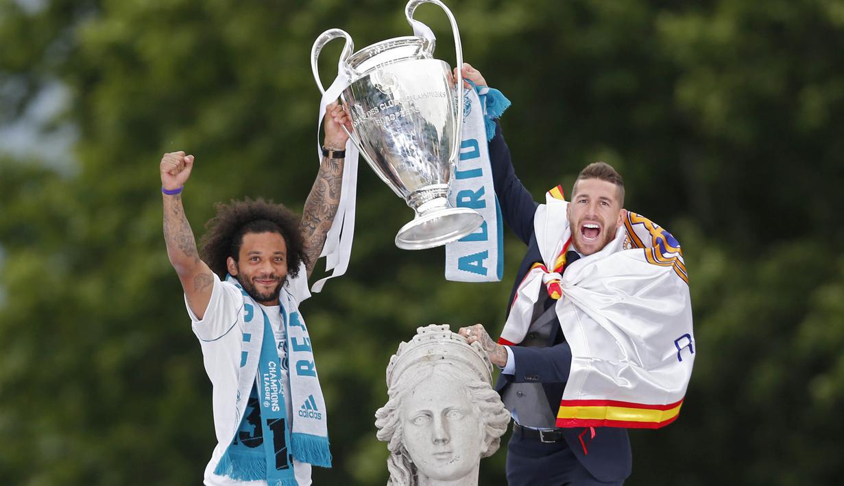 Pemain Real Madrid, Sergio Ramos dan Marcelo, mengangkat trofi Liga Champions di Monumen Cibeles, Madrid, Minggu (27/5/2018). Real Madrid menggelar pawai kemenangan bersama fans usai menjuarai Liga Champions 2018. (AP/Francisco Seco)