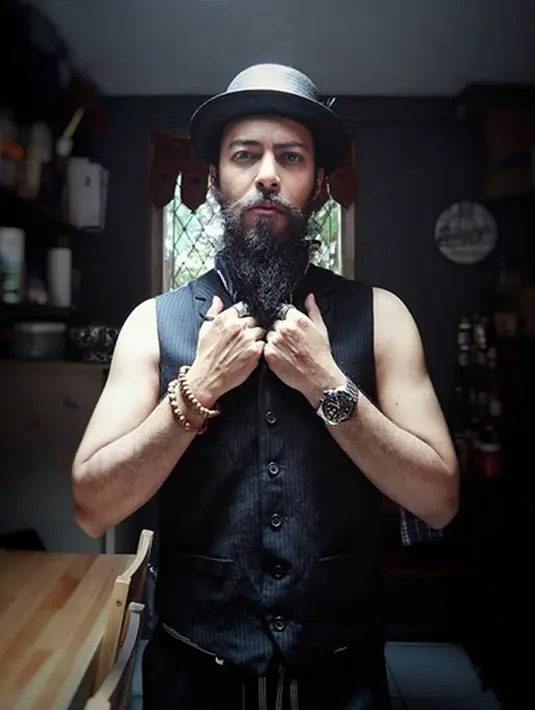 Tanpa memakai baju dalaman, Alex Abbad tampan banget dengan vestnya. Tak ketinggalan, dengan Panama di kepalanya. Untuk rambut gondrong keritingnya, Alex  memilih untuk dikuncir rendah. (Instagram/alexabbad)