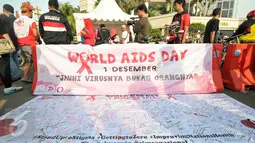 Sebuah spanduk petisi Peduli HIV/AIDS dibentangkan di kawasan Bundaran HI saat Car Free Day, Jakarta, Minggu (13/12/2015). Kegiatan tersebut dalam rangka memperingati hari AIDS sedunia. (Liputan6.com/Yoppy Renato)