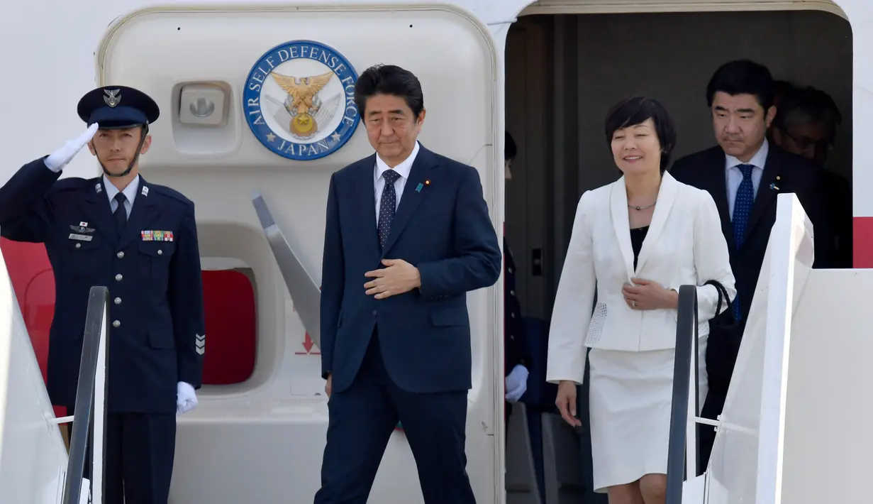 PM Jepang, Shinzo Abe dan istrinya, Akie Abe, saat akan turun dari pesawat setibanya di Hamburg, Jerman, Kamis (6/7). Sejumlah kepala negara telah tiba di Hamburg jelang pembukaan KTT G20 pada 7-8 Juli 2017.  (Bernd von Jutrczenka/dpa via AP)