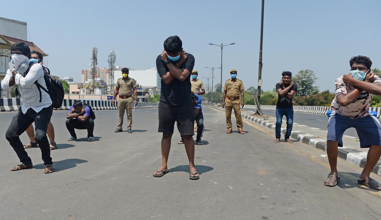 Orang-orang melakukan sit-up tanpa alas kaki sebagai hukuman karena keluar rumah selama pemberlakukan penguncian wilayah (lockdown) di Chennai, Rabu (1/4/2020). Pemerintah India menerapkan kebijakan karantina wilayah atau lockdown dalam memerangi Virus Corona COVID-19. (Arun SANKAR / AFP)