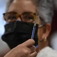 Perawat bersiap menyuntikkan dosis ketiga vaksin COVID-19 AstraZeneca di Centro de Estudios Superiores Navales (CENCIS) di Mexico City, Selasa (7/12/2021). Ibu kota Meksiko pada hari Selasa mulai memberikan vaksinasi booster untuk orang yang berusia di atas 60 tahun. (Pedro PARDO/AFP)