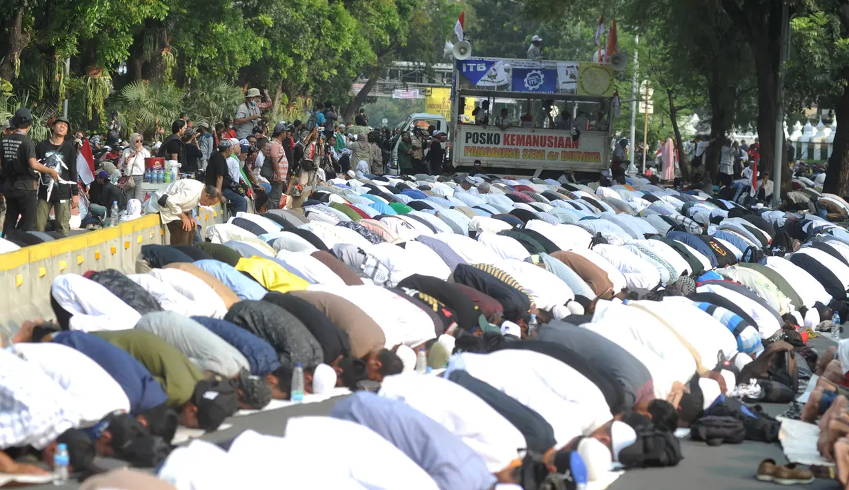 Massa pendukung pasangan capres-cawapres Prabowo Subianto dan Sandiaga Uno melakukan salat asar di Jalan Medan Merdeka Barat, Jakarta, Kamis (27/6/2019). Aksi tersebut dilakukan jelang putusan perselisihan hasil pemilihan umum (PHPU) Pilpres 2019 di Gedung MK. (merdeka.com/Arie Basuki)