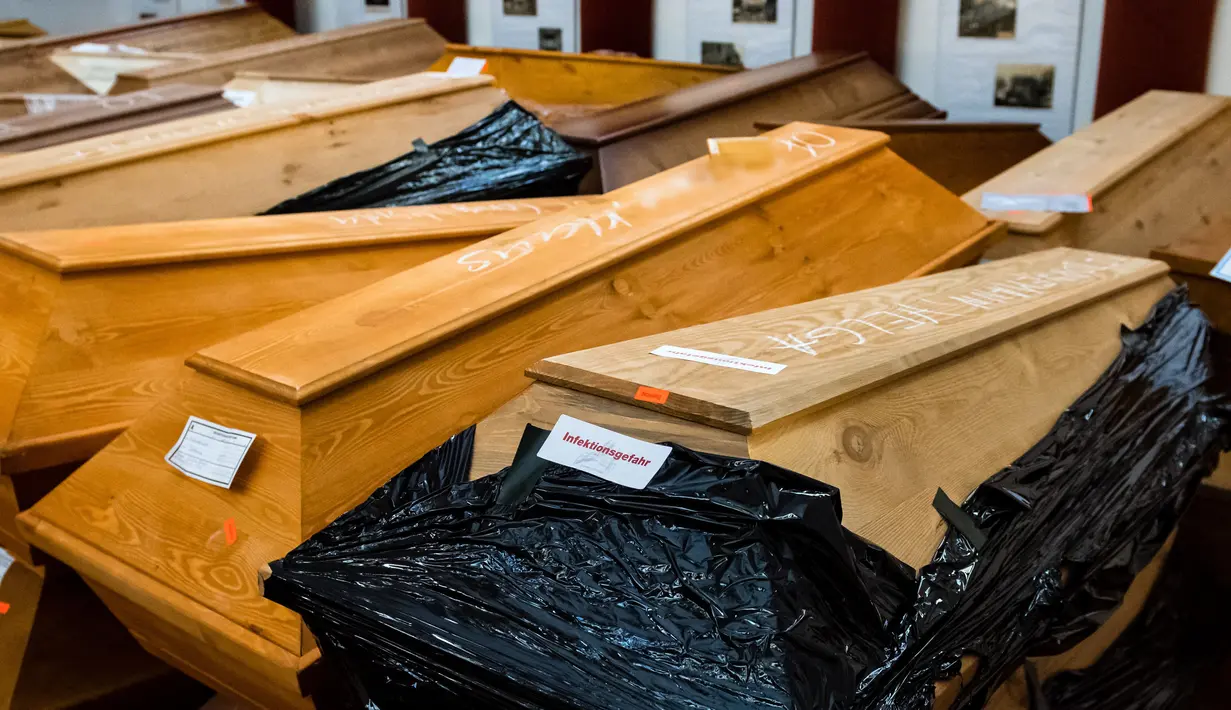 Pemandangan peti mati di ruang duka krematorium di Meissen, Jerman timur, 13 Januari 2021. Banyak di antara peti jenazah itu yang ditutup dengan plastik, diberi tulisan "risiko infeksi", "mendesak", atau hanya bertuliskan "COVID". (JENS SCHLUETER / AFP)