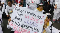 Peserta aksi mengangkat poster berisi pesan penolakan Rancangan Undang-Undang (RUU) Omnibus Law Kesehatan saat aksi di kawasan Patung Kuda Arjuna Wiwaha, Jakarta, Senin (8/5/2023). (Liputan6.com/Herman Zakharia)