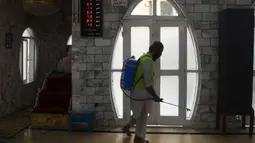 Seorang pekerja menyemprotkan disinfektan di masjid menjelang Ramadan selama penguncian nasional yang diberlakukan pemerintah sebagai tindakan pencegahan terhadap coronavirus COVID-19, di Karachi, Pakistan (21/4/2020). (AFP/Asif Hassan)