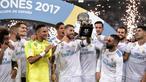 Sergio Ramos (tengah) mengangkat trofi Piala Super Spanyol 2017 usai mengalahkan Barcelona  pada leg kedua Piala Super Spanyol di Santiago Bernabeu stadium (16/8/2017). Real menang 2-0. (AFP/Javier Soariano)