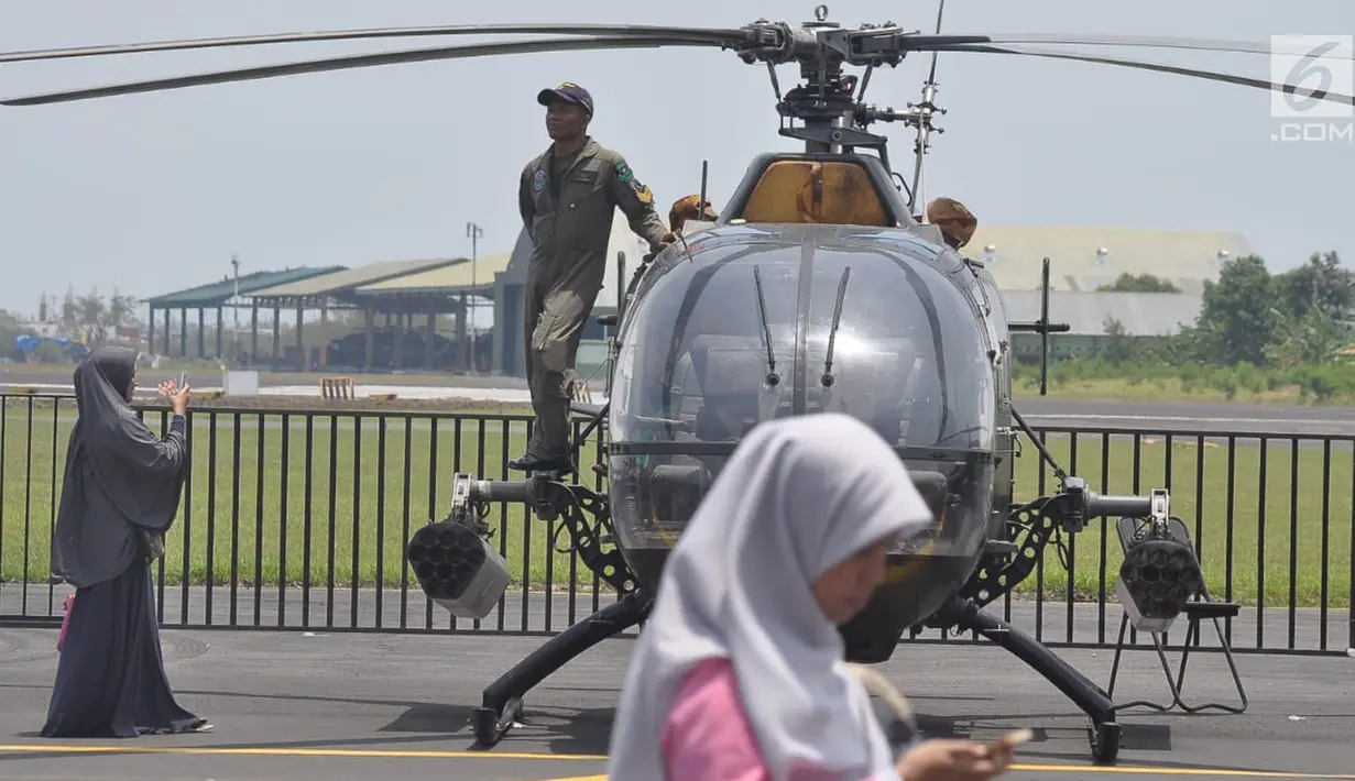 Seorang prajurit  berdiri di sebuah helikopter milik TNI AD ada pameran alat utama sistem persenjataan (Alutsista) di Lanumad  Ahmad Yani Semarang, Jumat (5/10). Pameran alutsista tersebut dalam rangka memeriahkan HUT Ke-73 TNI. (Liputan6.com/Gholib)
