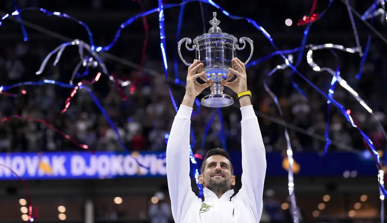 Petenis asal Serbia, Novak Djokovic, mengangkat trofi gelar juara US Open 2023 setelah mengalahkan petenis asal Rusia Daniil Medvedev dalam partai final yang berlangsung di Arthur Ashe, New York, Senin (11/9/2023) pagi WIB. Trofi ini merupakan gelar US Open keempat kalinya, dari 10 kali final yang telah dijalani oleh Djokovic. (AP Photo/Manu Fernandez)