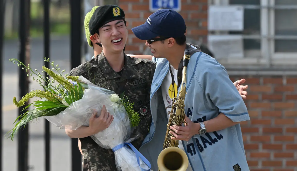 RM yang saat ini sedang menjalani wamil sebagai anggota band militer, bahkan memeriahkan suasana dengan membawa saksofon. (Jung Yeon-je / AFP)
