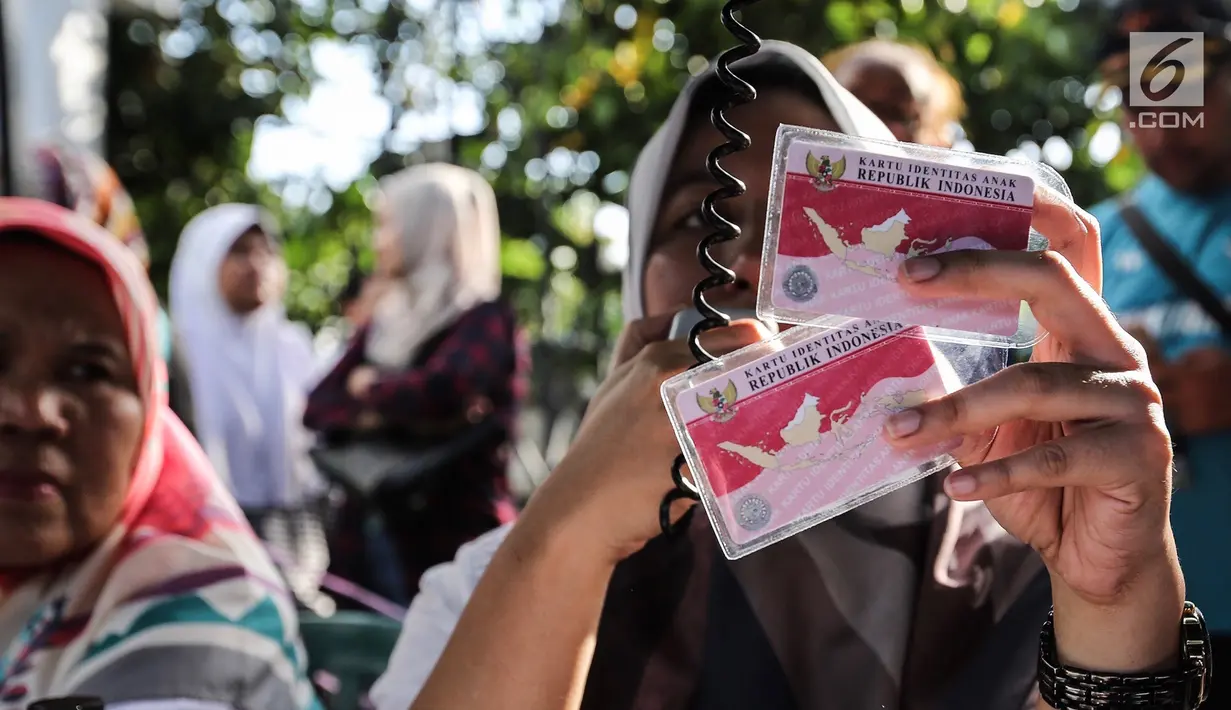 Petugas Disdukcapil membagikan Kartu Identitas Anak (KIA) di Pondok Aren, Tangerang Selatan, Jumat (16/11). Penerbitan KIA bertujuan untuk meningkatkan pendataan, perlindungan dan pelayanan publik. (Liputan6.com/Fery Pradolo)