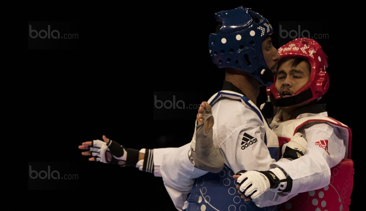 Atlet taekwondo Indonesia, Dinggo Ardian (merah), saat melawan Morrison Samuel, pada final kelas kyorugi -74 kg SEA Games di KLCC, Kuala Lumpur, Minggu (27/8/2017). Kalah di final, Dinggo harus puas meraih perak. (Bola.com/Vitalis Yogi Trisna)