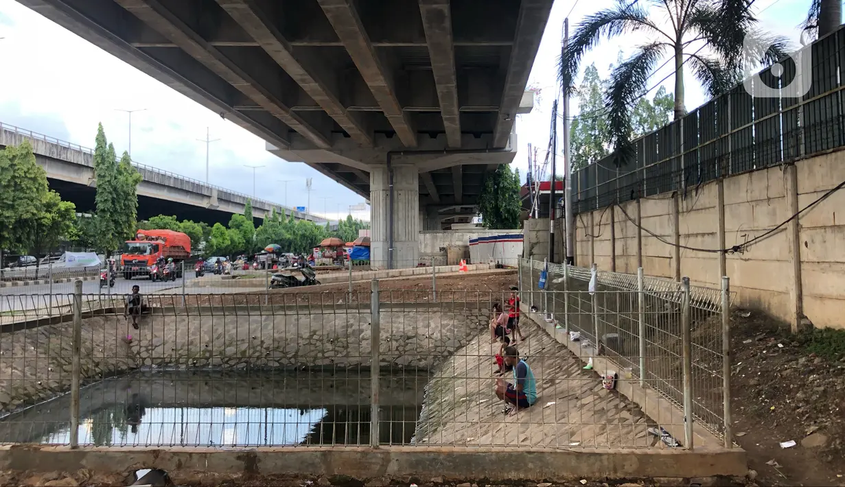 Sejumlah warga memancing ikan di kubangan yang berada di Jalan DI Panjaitan, Jatinegara, Jakarta, Selasa (16/6/2020). Meski telah dipagari, sejumlah warga tetap memancing ikan di lokasi yang merupakan saluran pembuangan tersebut. (Liputan6.com/Immanuel Antonius)