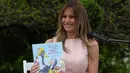 Melania Trump menunjukan buku cerita anak "Party Animals" saat perayaan Paskah ke-139 di halaman selatan Gedung Putih, Washington, Senin (17/4). (AP Photo/Carolyn Kaster)