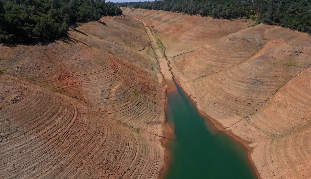 Pantauan udara memperlihatkan volume air waduk yang menyusut parah di Danau Oroville di Oroville, California pada (1/6/2021). Musibah kekeringan ekstrem di California telah membuat ketinggian air di waduk tersebut turun dengan cepat. (AFP/Justin Sullivan)