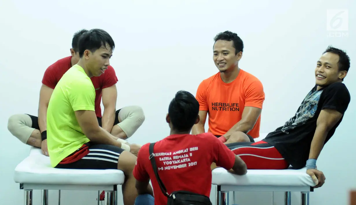 Sejumlah lifter putra Indonesia bercengrama disela-sela latihan tes prestasi pelatnas angkat besi Asian Games 2018 di Mako Lanmar Jakarta, Selasa (6/3). Tes ini untuk mengukur kemajuan atlet jelang Asian Games 2018. (Liputan6.com/Helmi Fithriansyah)